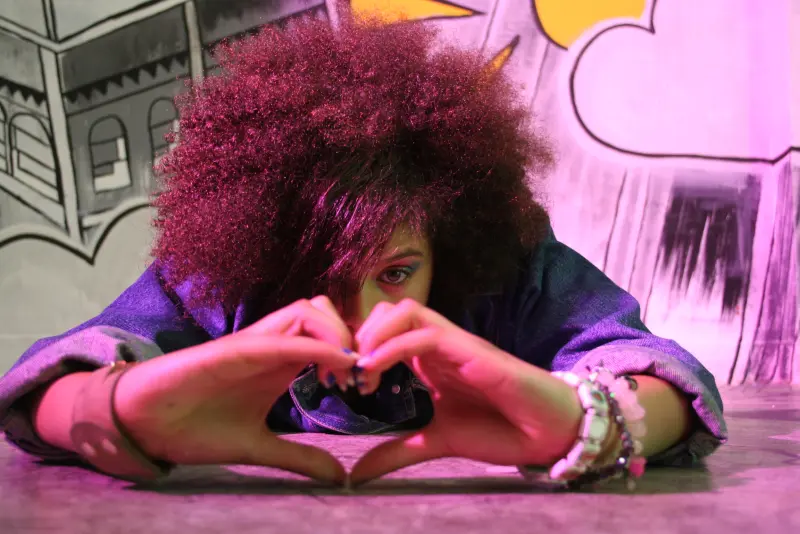 young woman making a heart shape with her hands